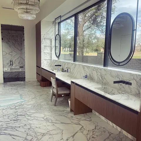 Twin black-framed oval mirrors above a marble double vanity, installed by Glass Squad